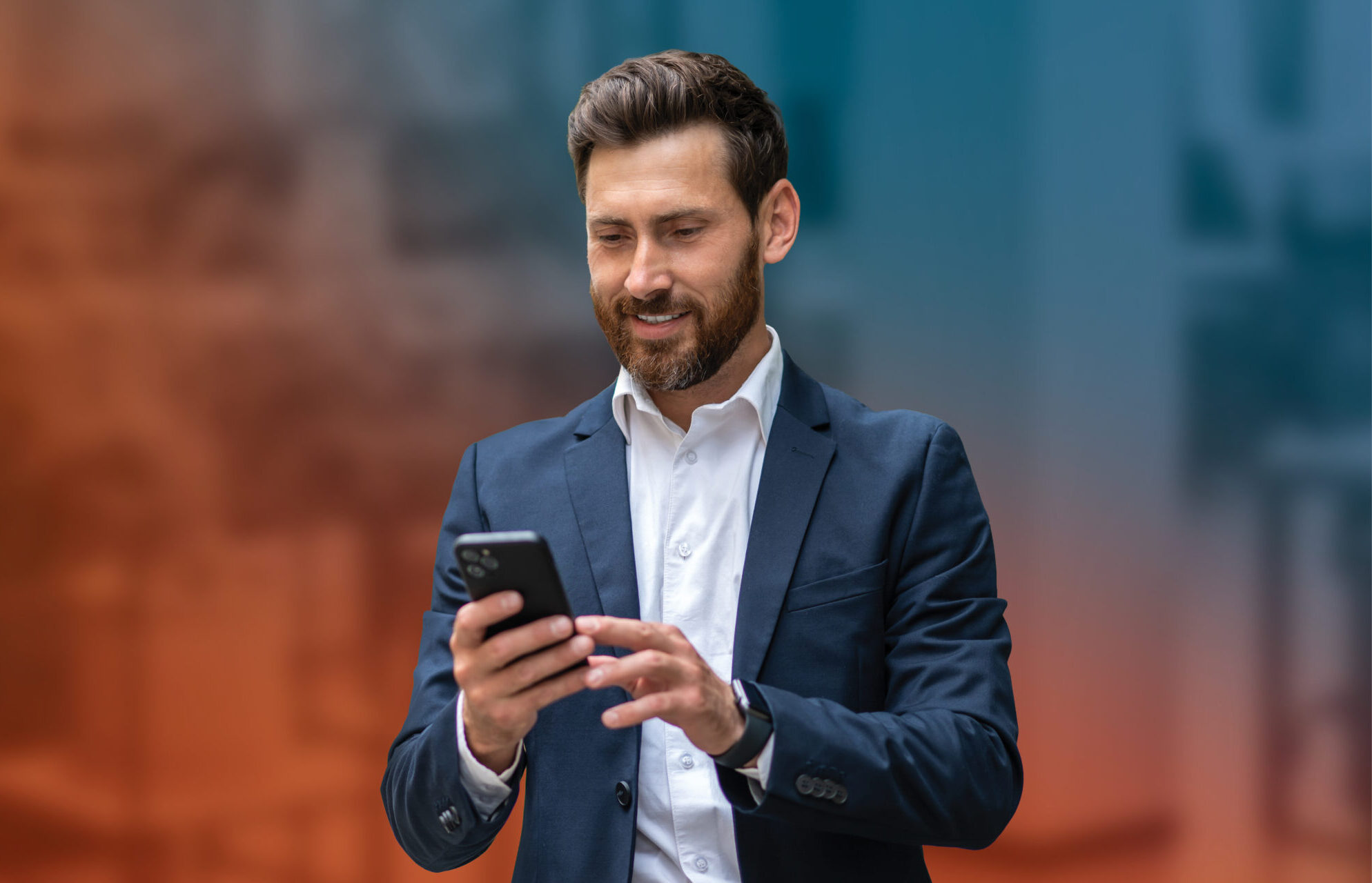 A businessman in a suit uses his cell phone for online banking, showcasing 1st Source Bank's modern financial management tools.