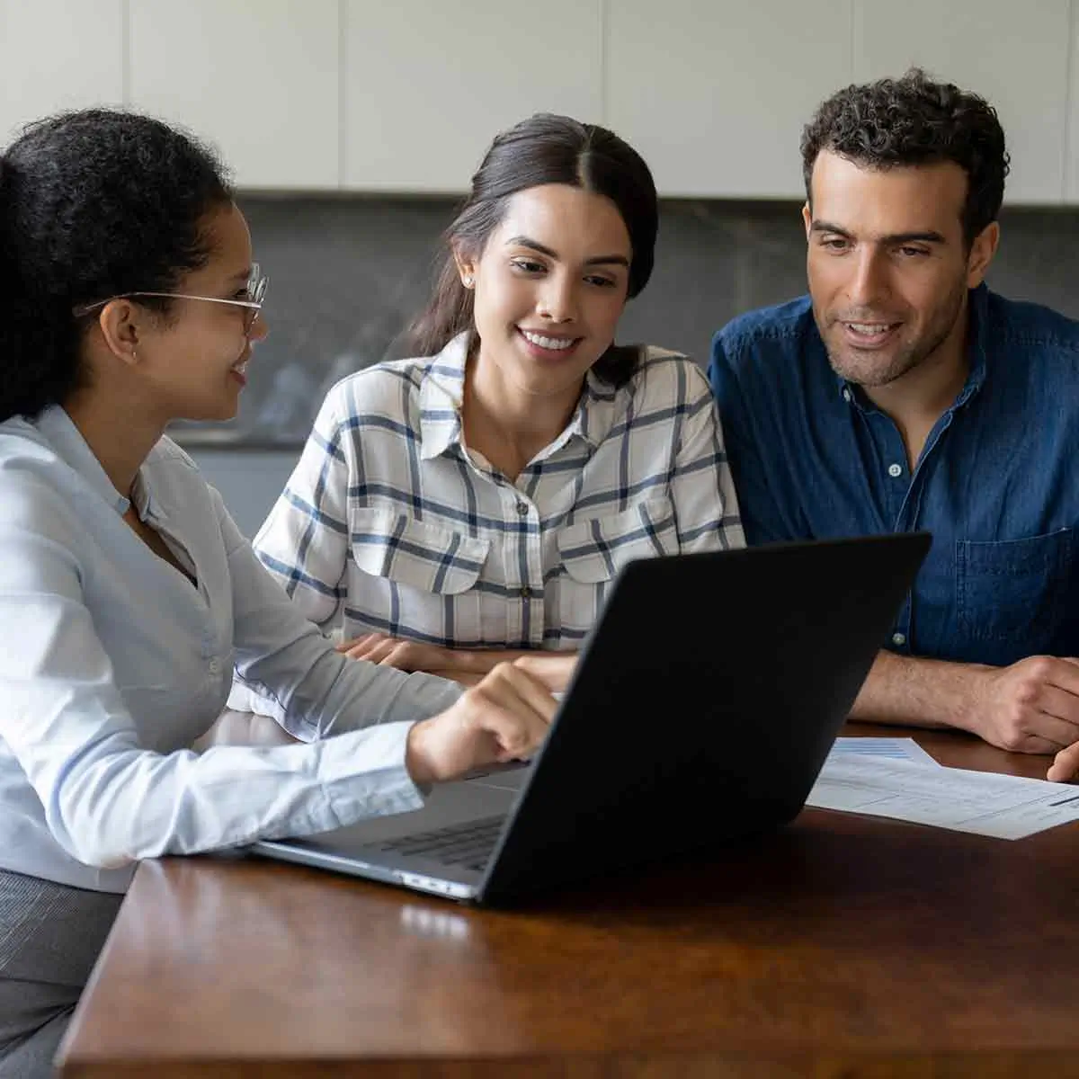 Banker showing her computer screen to a couple, explaining Certificates of Deposits (CDs) and other investment options