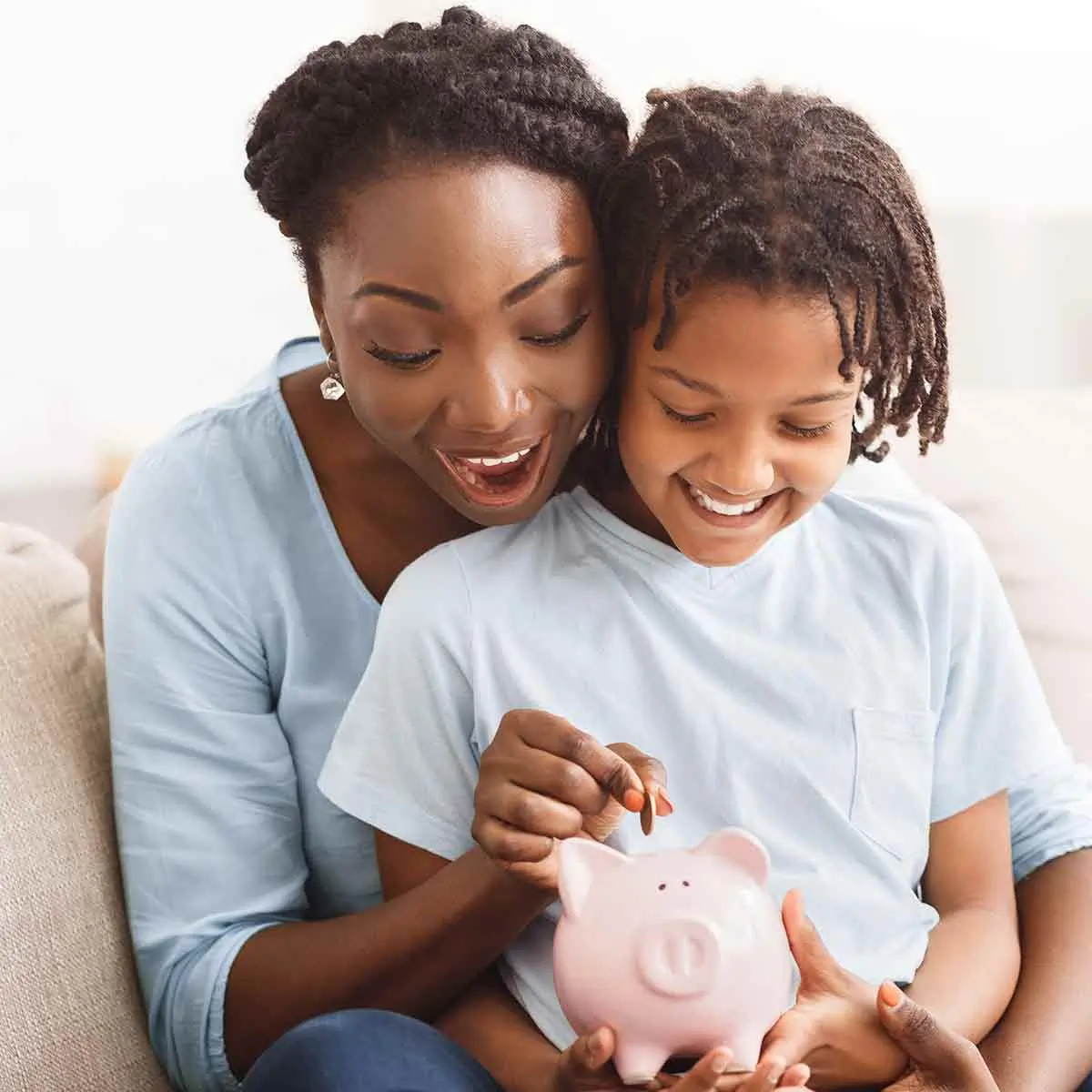 Mother and child putting a coin in a piggy bank, representing the importance of financial education.