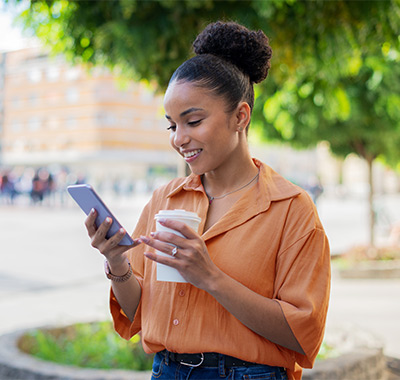 A young woman using her cell phone to securely manage her 1st Source Bank debit cards