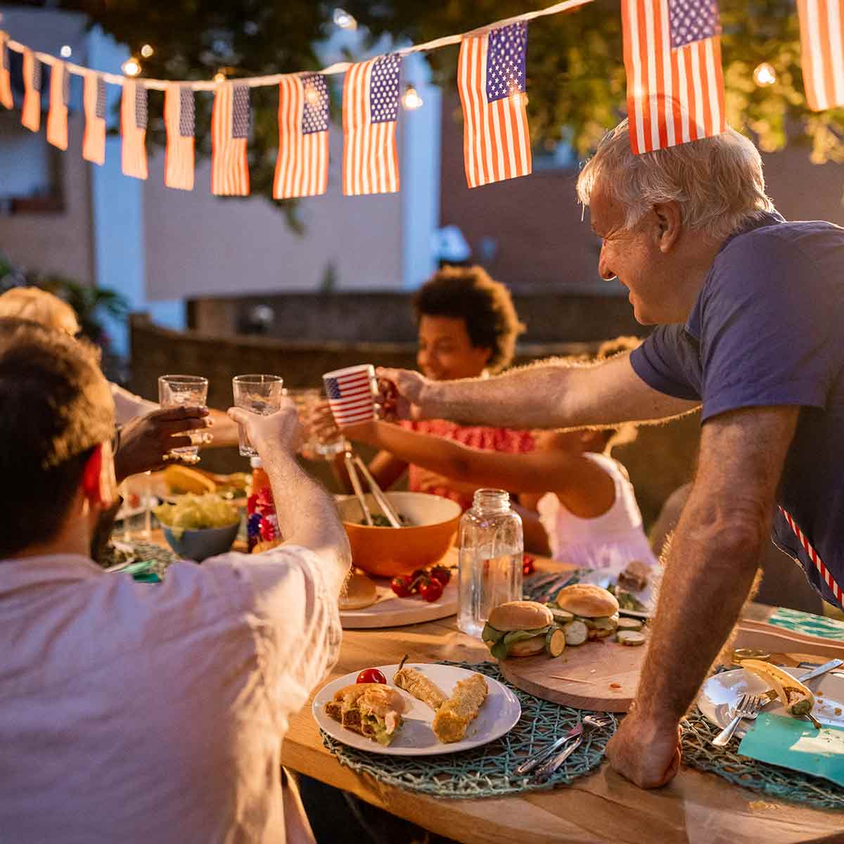 A family celebrates July 4th with an outdoor party in the evening.