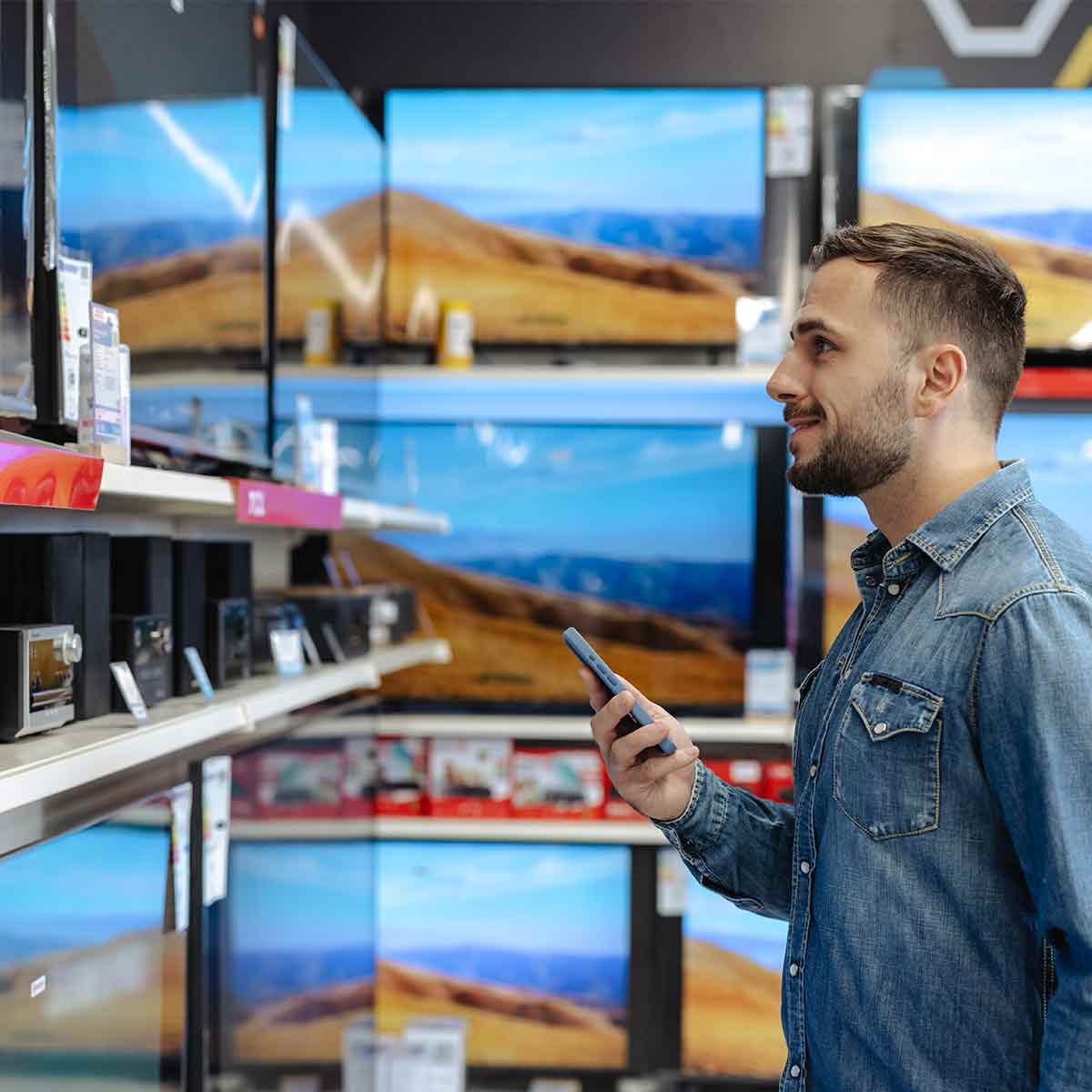 A man shops for a TV in a retail store, reflecting high consumer confidence and economic activity