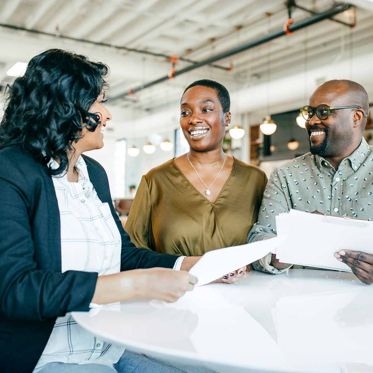 A couple reviews documents with their financial advisor, discussing inheritance planning, trusts, and avoiding probate.