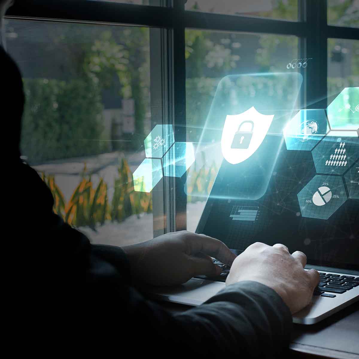 A computer hacker in a dimly lit room, surrounded by cybersecurity threat icons