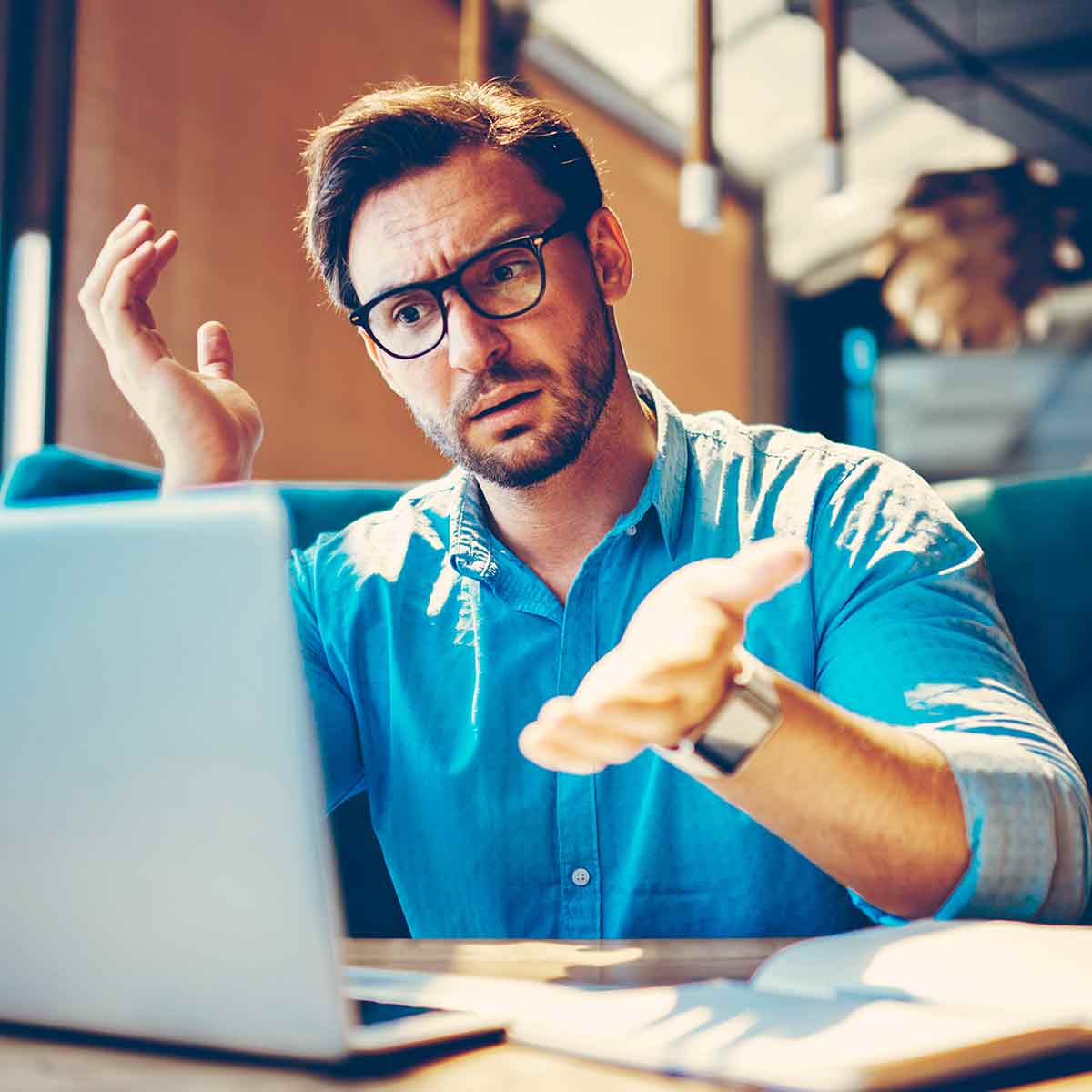 A man working on his laptop, confused about the latest cybersecurity threats and online banking scams