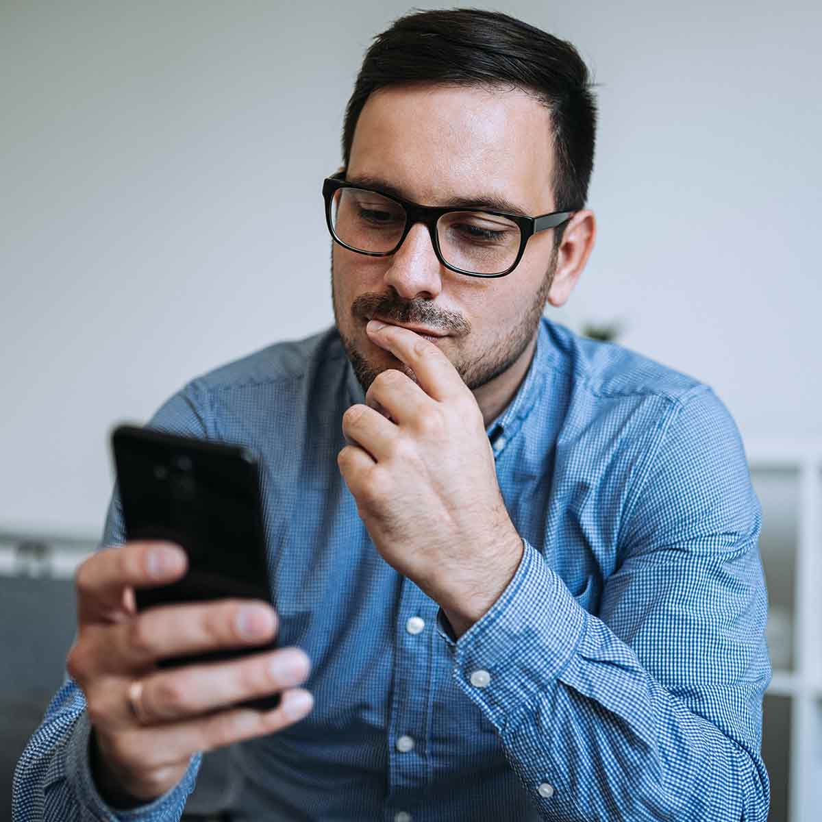 Man reading 401(k) information on phone and thinking about options