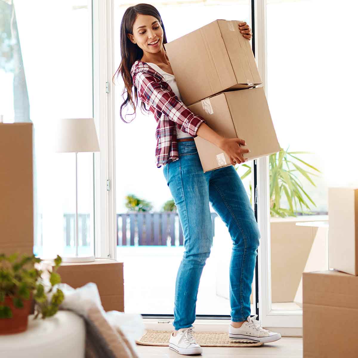 A first-time homebuyer moves boxes into her new house