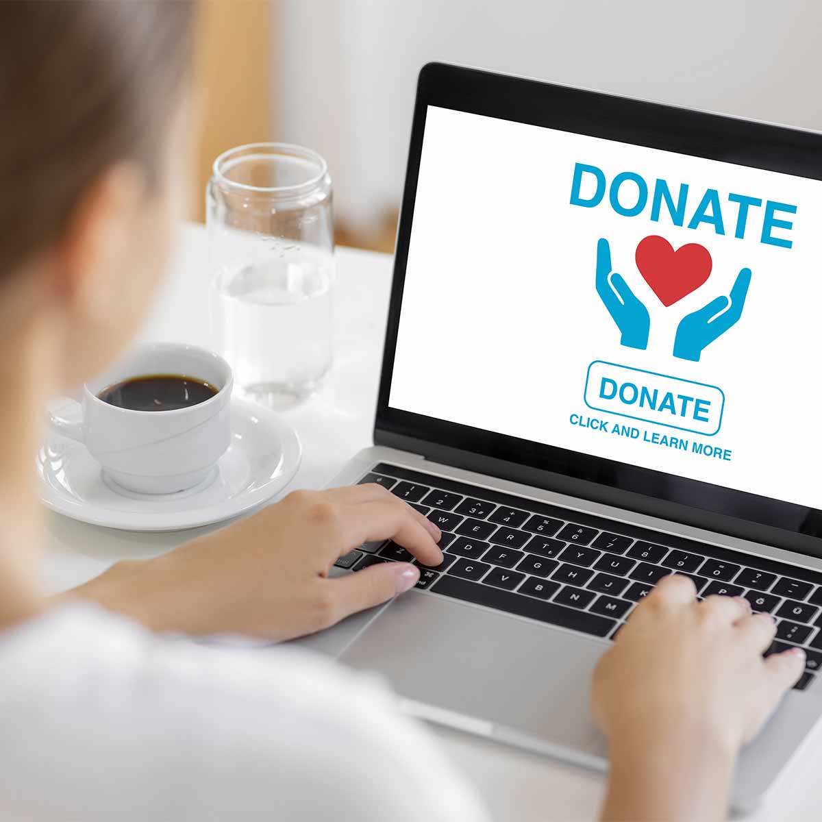 A woman carefully reviewing a charity donation request on her laptop to make sure it is not a scam