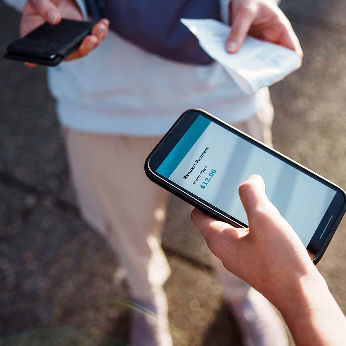 Two people exchanging money through a peer-to-peer payment app on their phones