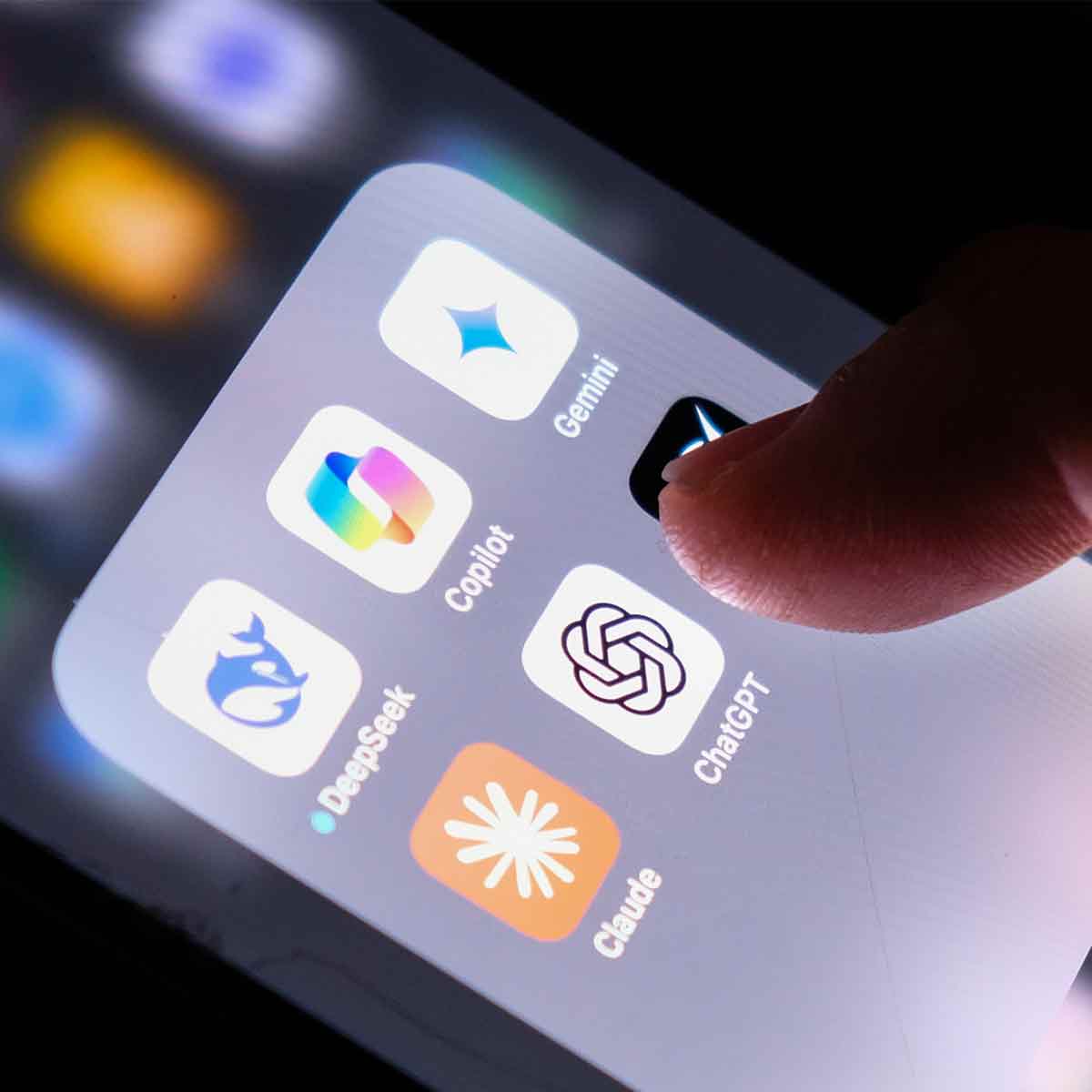 Close-up of a finger tapping AI apps on a smartphone screen including ChatGPT, Copilot, Claude, Gemini, and DeepSeek