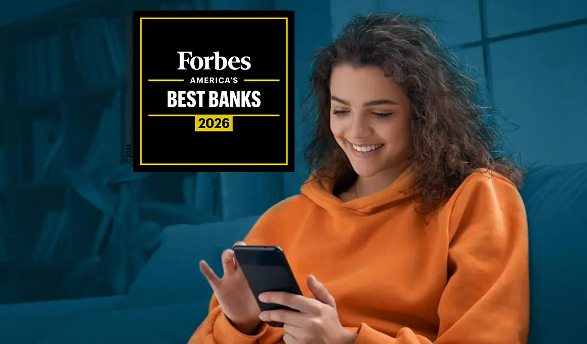 A young woman on her couch, opening a bank account online with her smartphone.