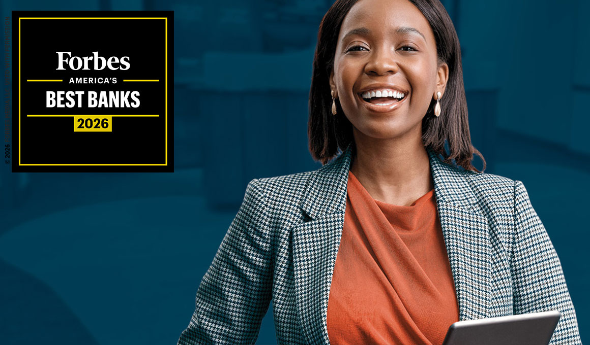 A smiling businesswoman holding her laptop