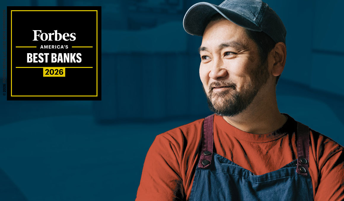 Smiling small business owner wearing a utility apron and baseball cap