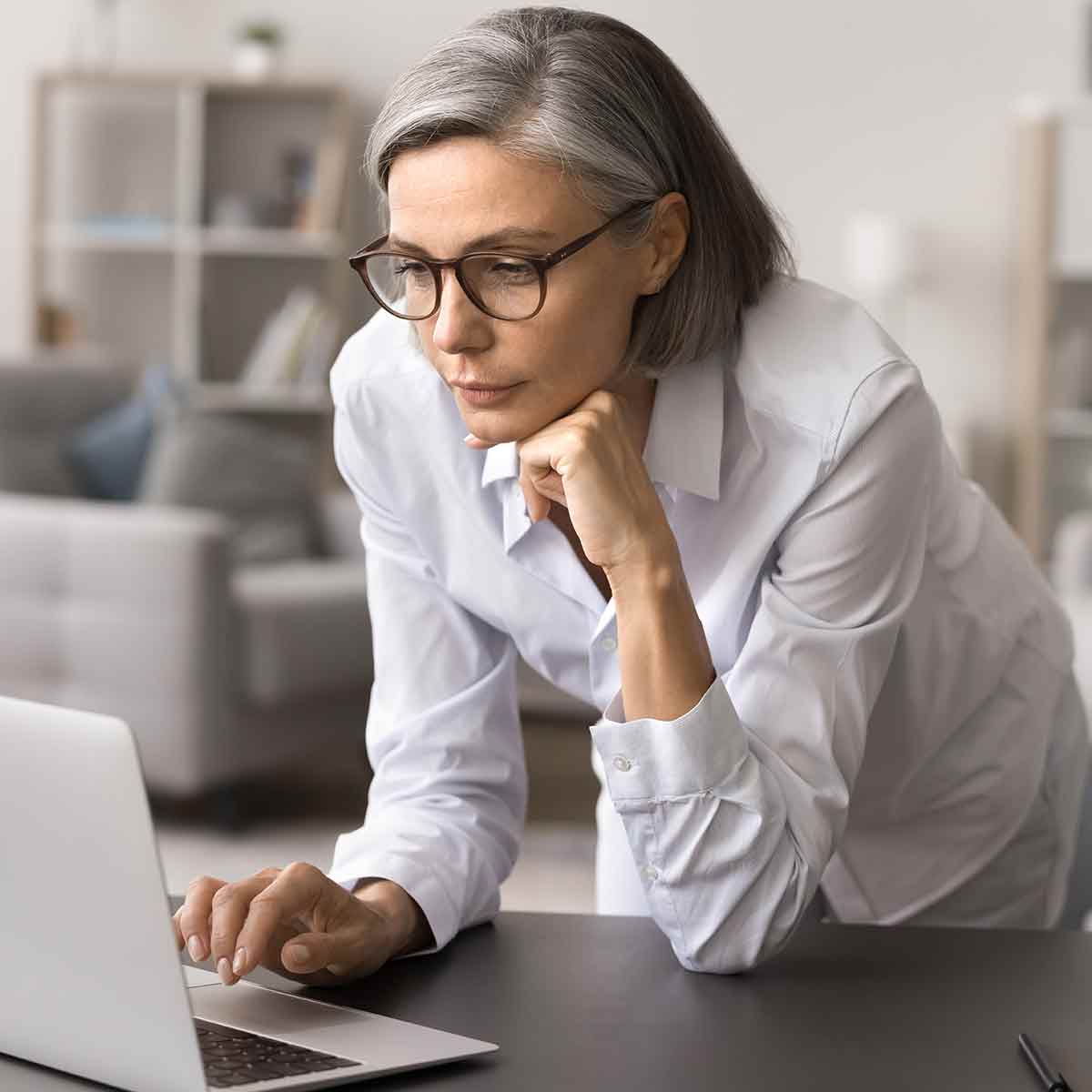 Investor using a laptop with a thoughtful expression, reflecting on stock market changes