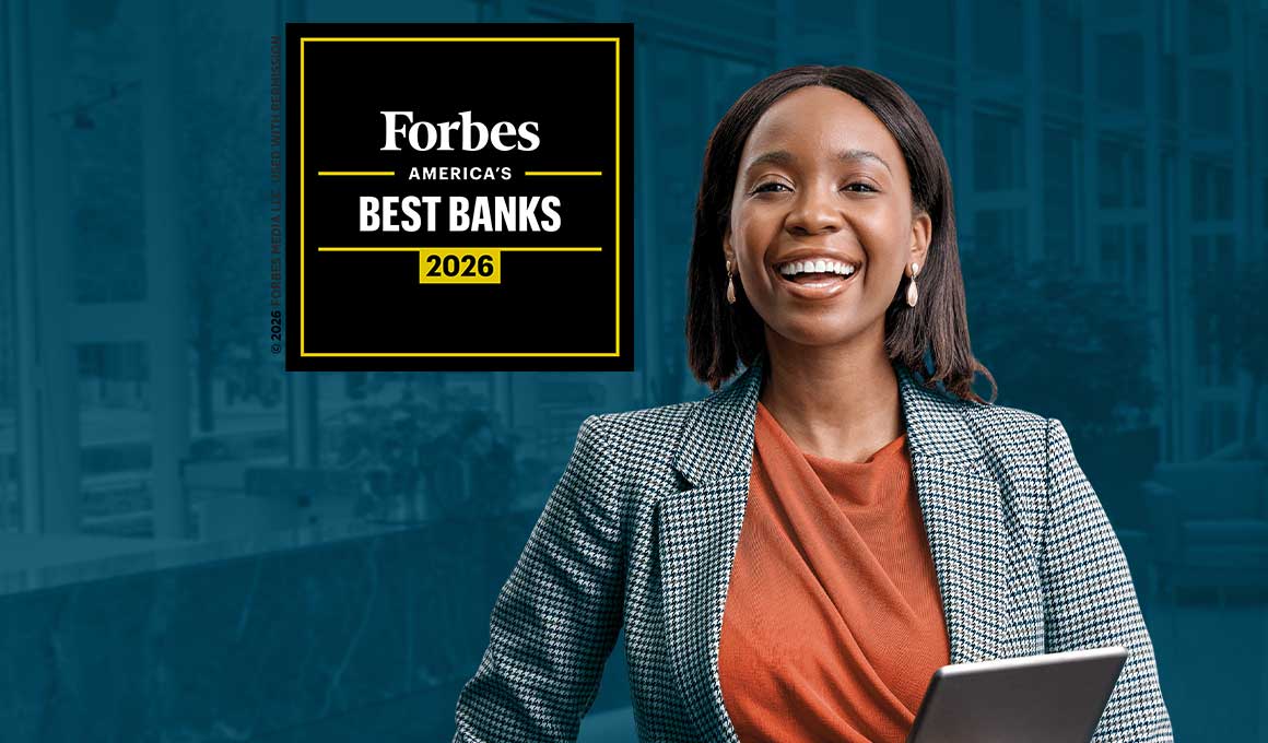 A smiling businesswoman holding her laptop