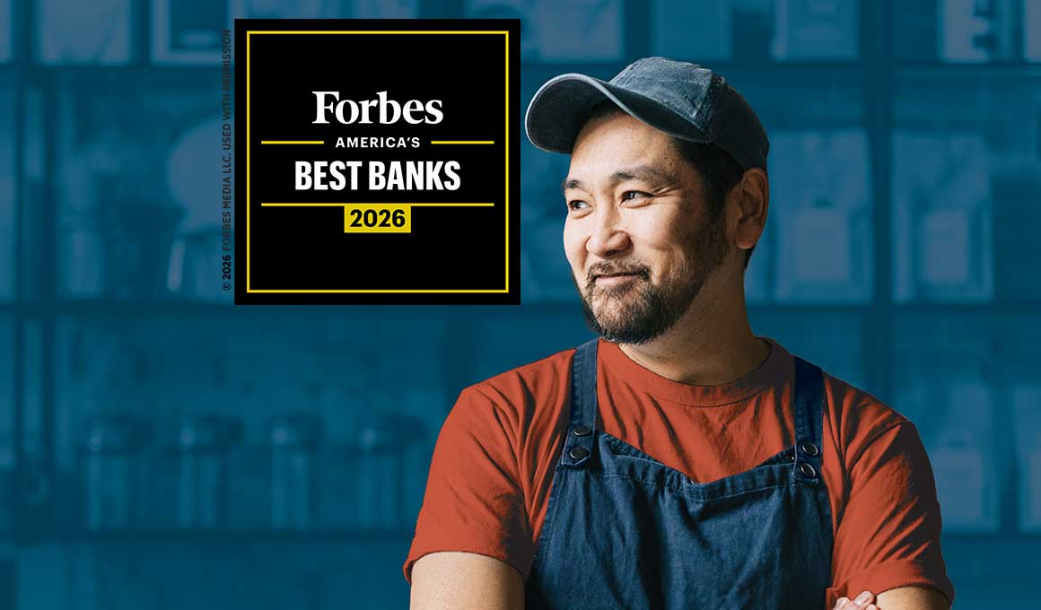Smiling small business owner wearing a utility apron and baseball cap