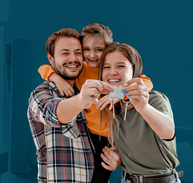 A cheerful family holds up their keys, celebrating purchasing their new home.