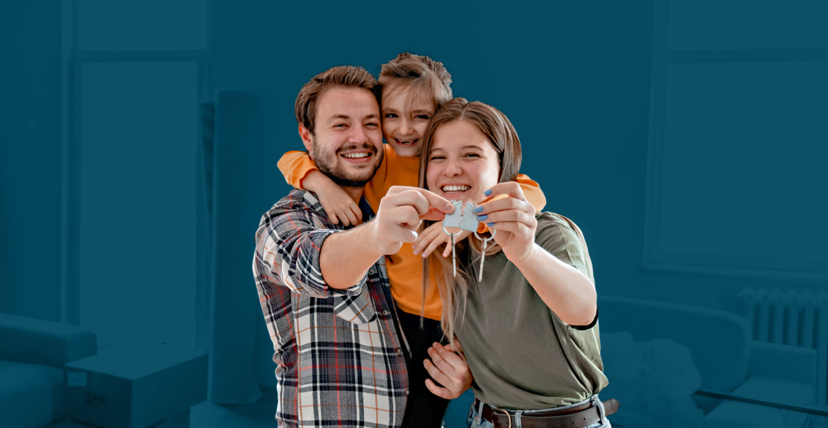 A cheerful family holds up their keys, celebrating purchasing their new home.
