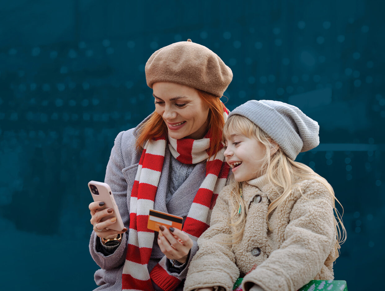 A mother and daughter reviewing spending and budget tools in the mobile banking app