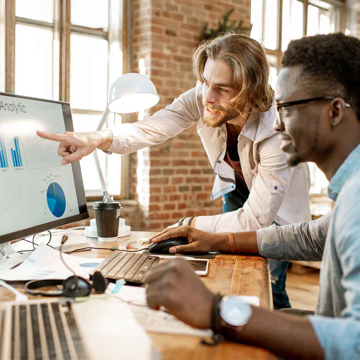 Investment professionals reviewing a chart of market trends on an office computer
