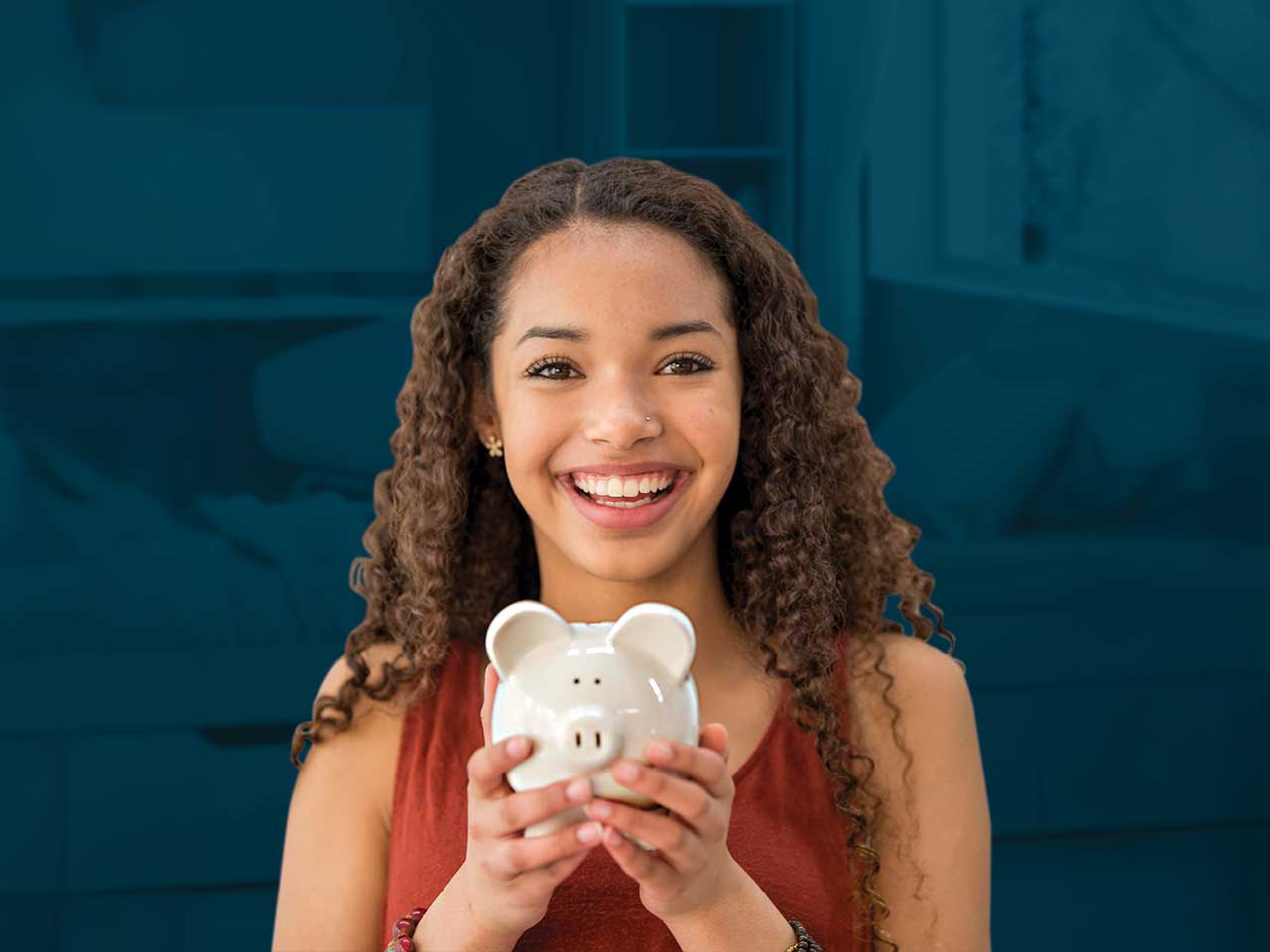 A student holding a piggy bank, a symbol for her savings account and financial wellness