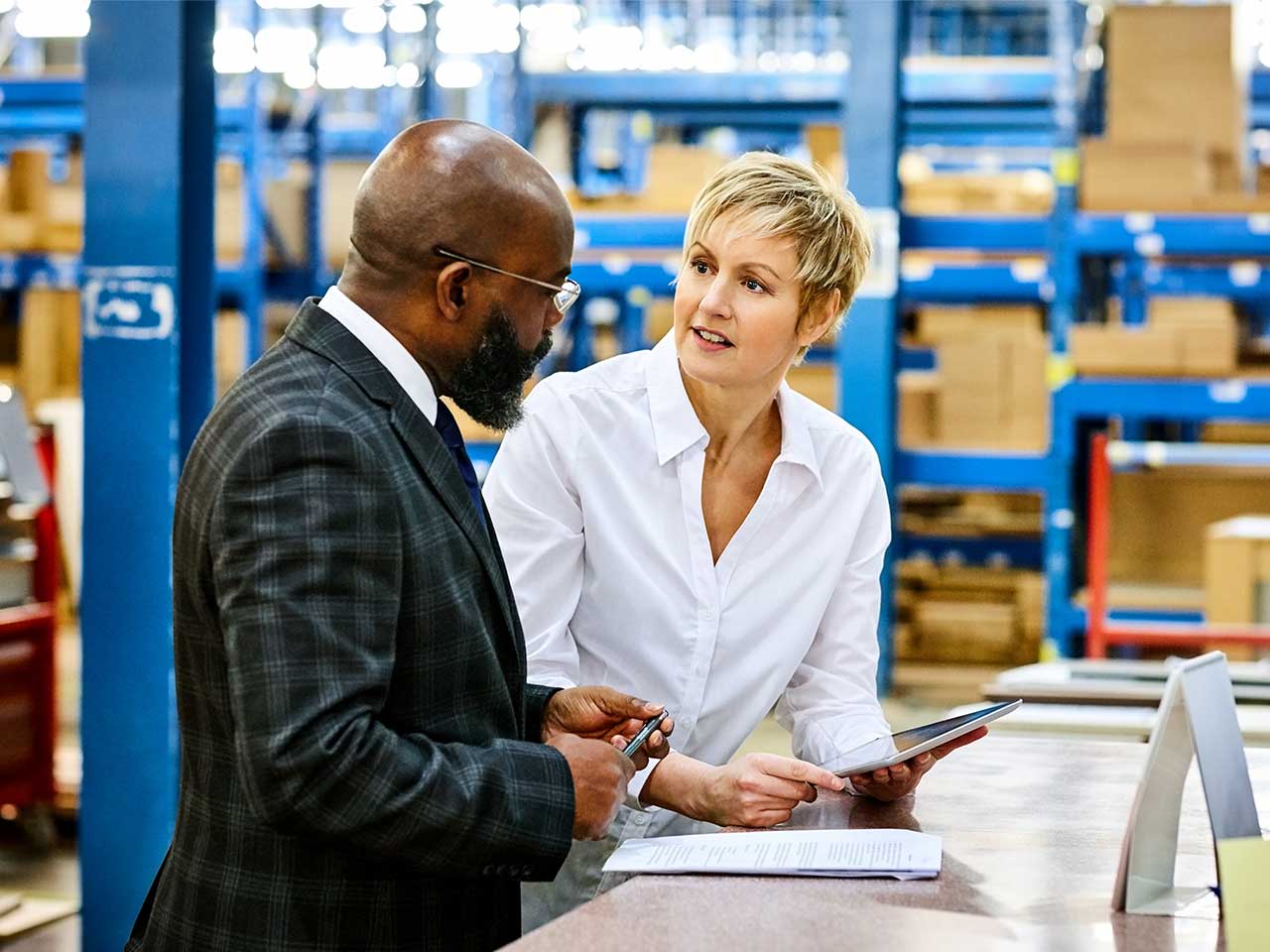 A 1st Source advisor and a business owner discuss business succession planning inside a warehouse
