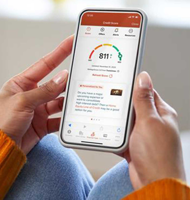 Woman using the 1st Source Bank app on her phone to improve her credit score
