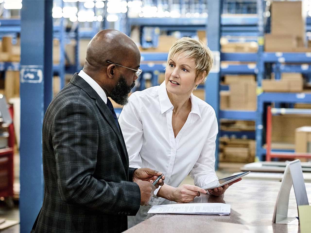 A 1st Source advisor and a business owner discuss business succession planning inside a warehouse