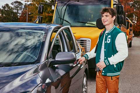 An older teenager taking his car to school, showing his growing financial capabilities due to Greenlight financial education