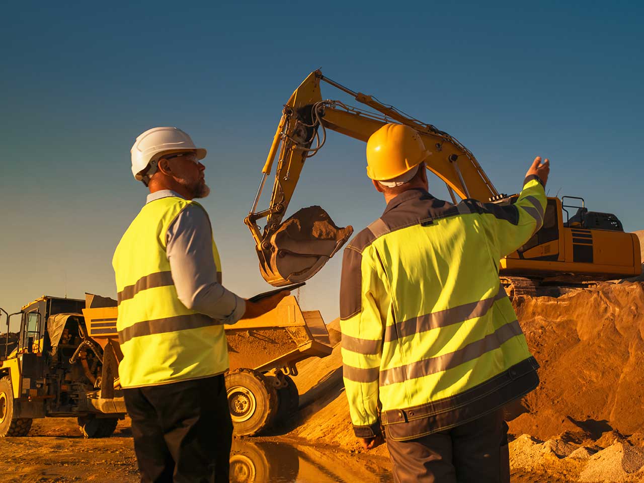 Construction professional with heavy equipment at an active job site